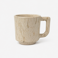A rustic ceramic mug with a textured, speckled beige and cream glaze, featuring a thick integrated handle, shown on a clean white background.