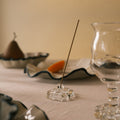 Incense stick in a glass holder on a table with a blurred background