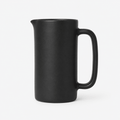 Black ceramic pitcher on a white background