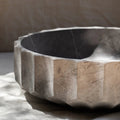 Decorative stone bowl with a textured surface on a neutral background