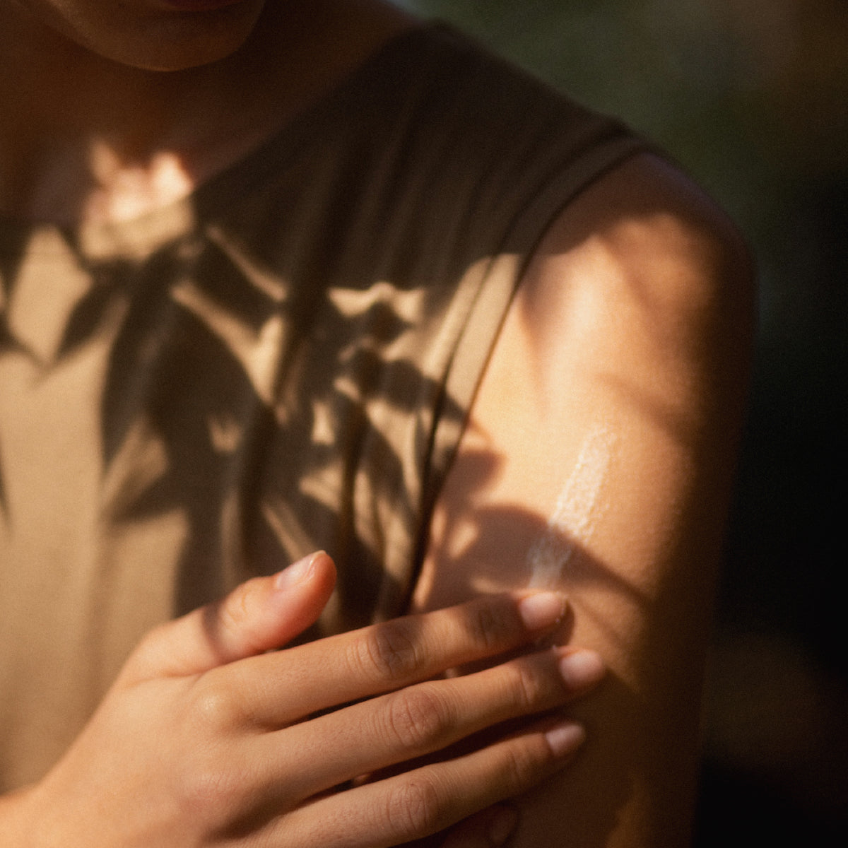 A woman rubbing Shea Whipped Lotion on her arm.