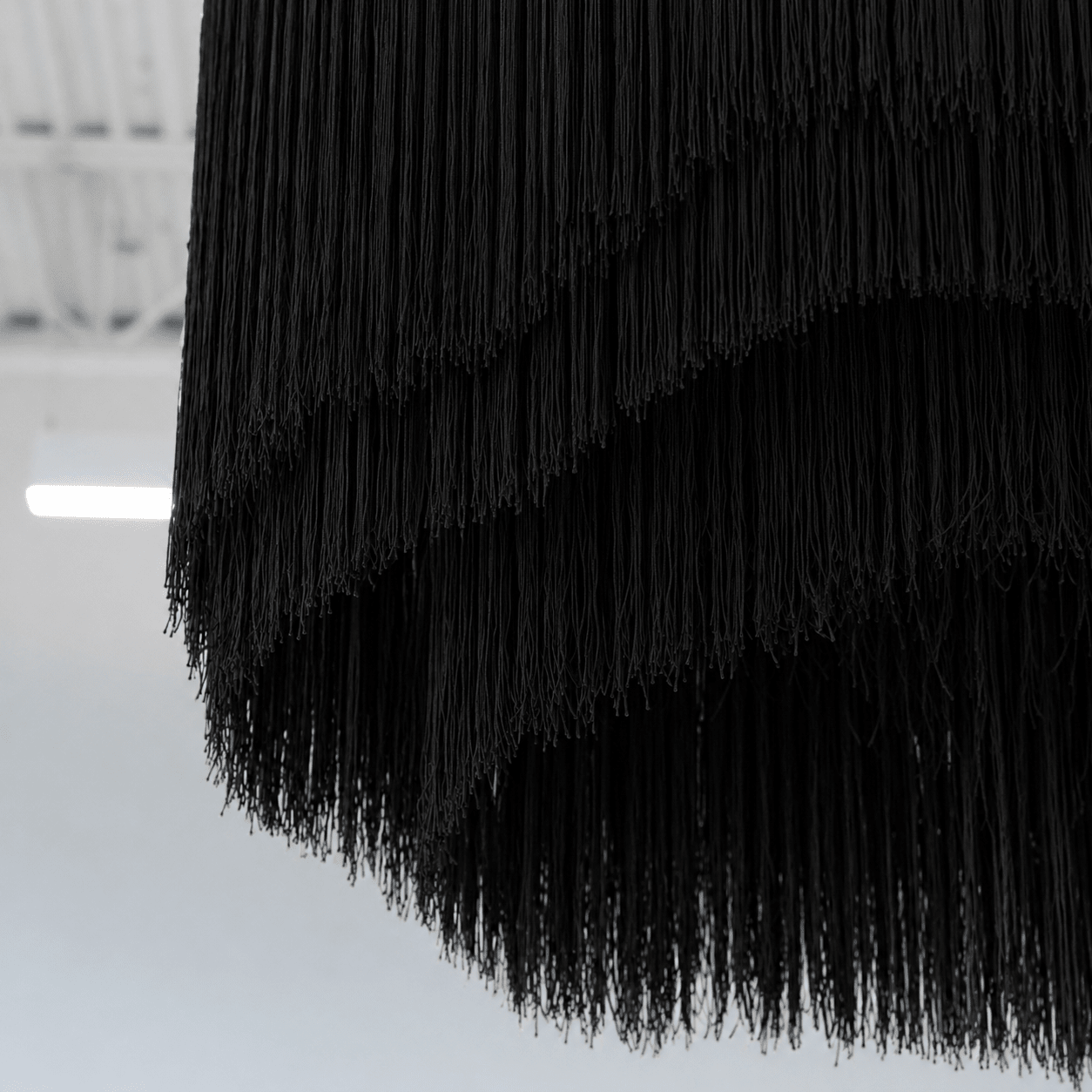Close-up of black fringe fabric on a white background