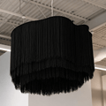 Black fringed pendant light hanging from a ceiling
