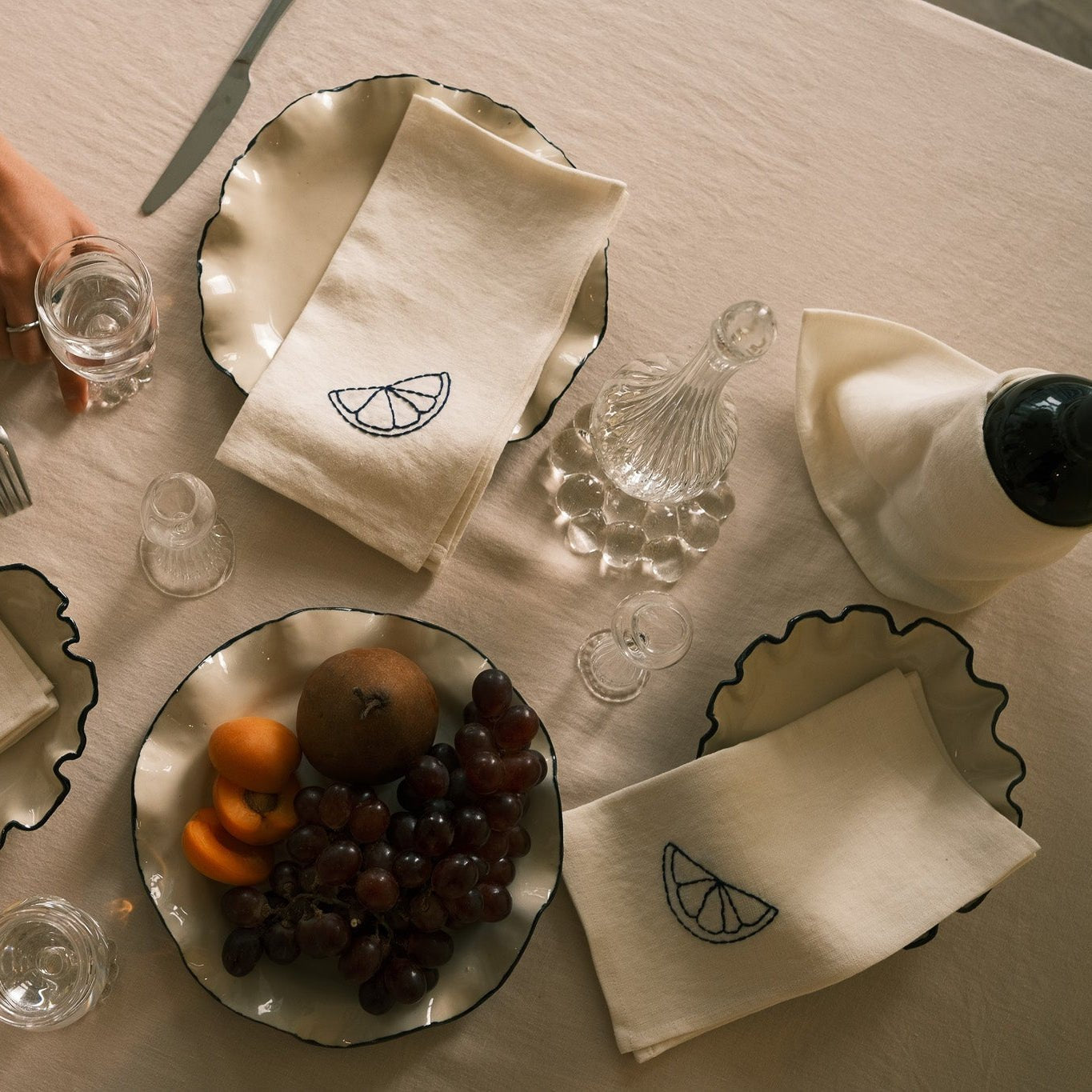 Table setting with embroidered napkins from Sarah Espute and ruffle plates handmade by Nathalee on the table.