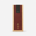 A rectangular incense box with a light natural wood frame and a dark reddish-brown lid featuring concentric circular texture, a black 'hitotoki' label near the top, and gold Japanese characters with the word 'Musk' below.