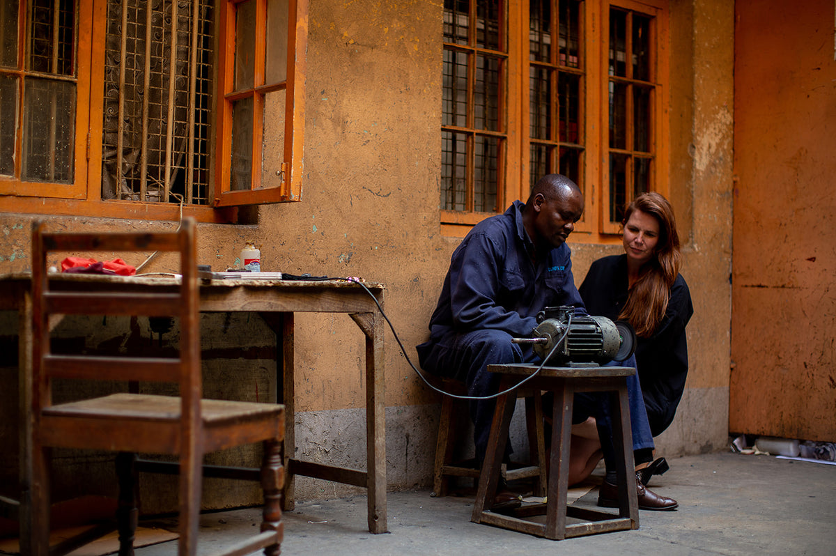 A man showing Treana how he polishes jewelry.
