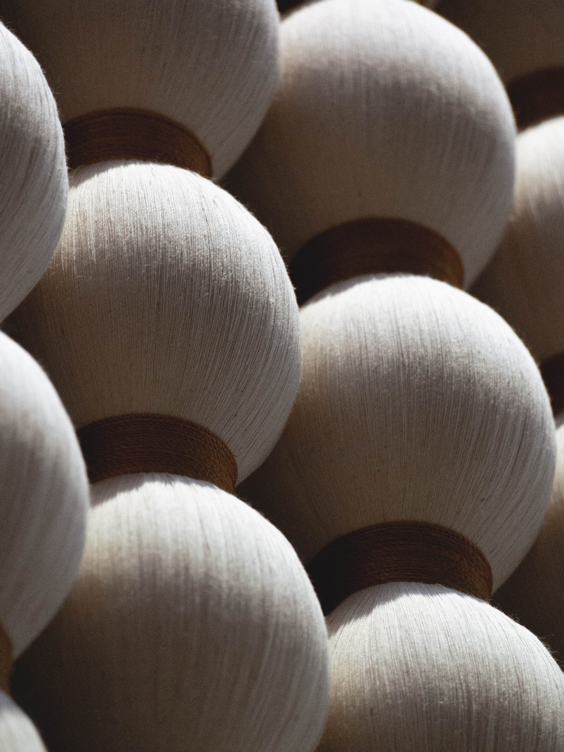 Close-up of wooden beads with a focus on texture and color variation of Caralarga wall hangings.