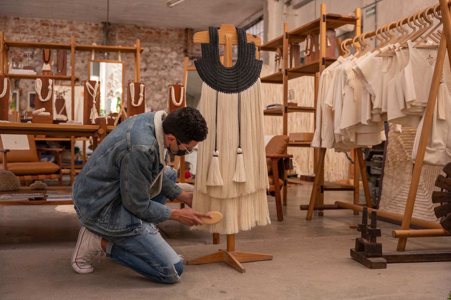A man at Caralarga brushing a wall hanging.