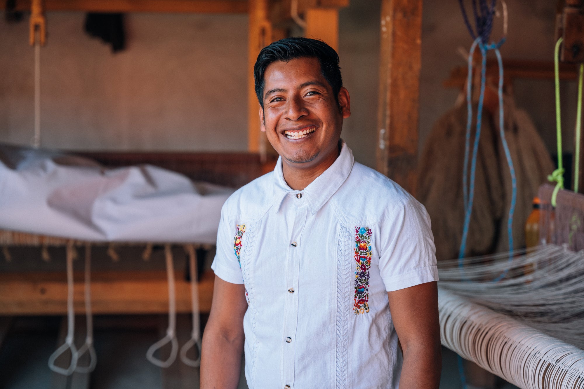 Jose Mendoza smiles at the camera in his workshop.