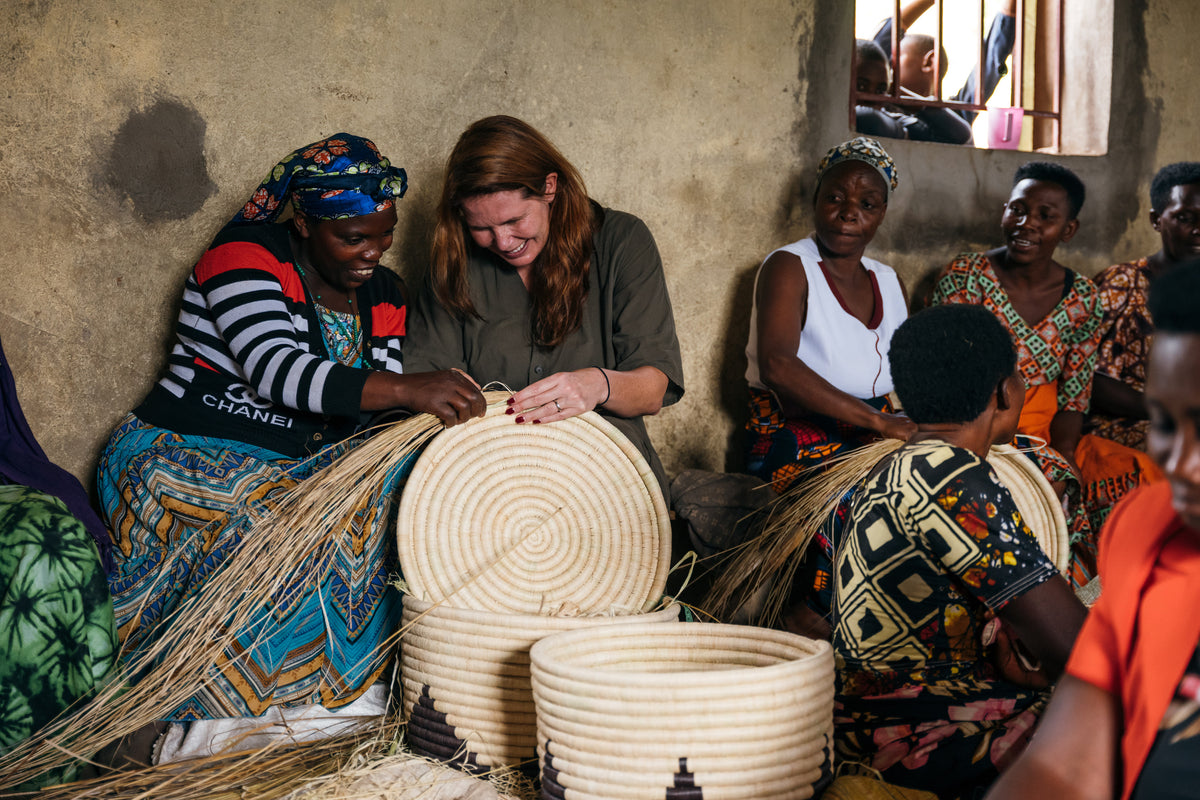 Treana trying to weave a basket with the artisans of Kasese.