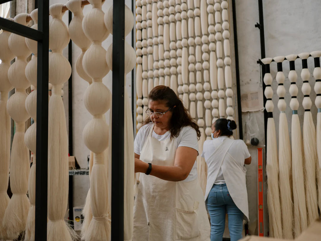 Two women working with yarn in a textile factory - caralarga.