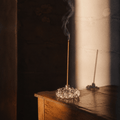 Incense stick with smoke on a wooden table against a dark background