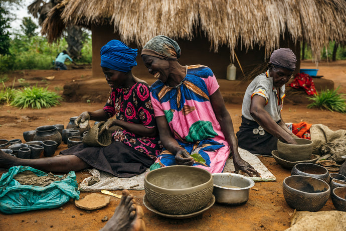 A group of women molding pottery.
