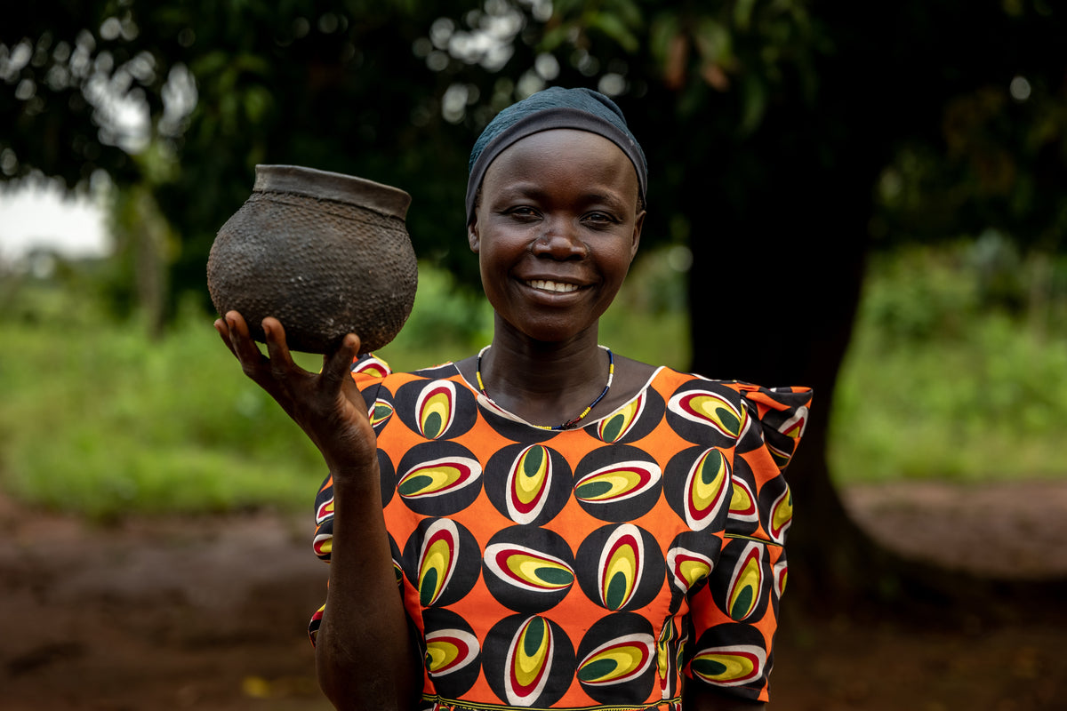A woman holding a clay planter.