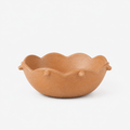 Brown ceramic bowl with scalloped edge on a white background